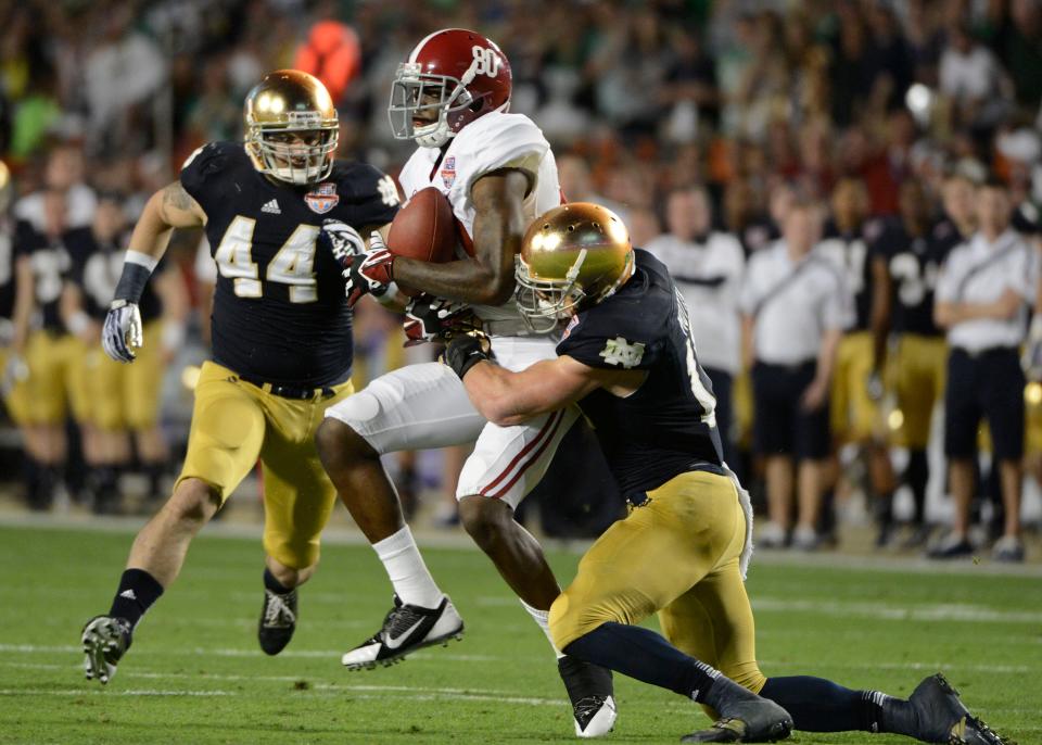 Jan 7, 2013; Miami, FL, USA; Alabama Crimson Tide wide receiver Marvin Shinn (80) is hit as he attempts to catch a pass by Notre Dame Fighting Irish safety Zeke Motta (17) as Carlo Calabrese (44) closes in during the first half of the 2013 BCS Championship game at Sun Life Stadium. Mandatory Credit: Eileen Blass-USA TODAY Sports