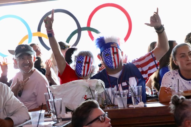 Fans wear red, white and blue masks as they celebrate...