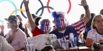 Fans wear red, white and blue masks as they celebrate...