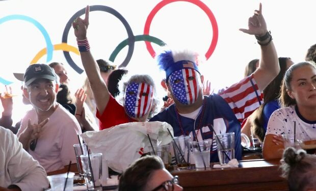 Fans wear red, white and blue masks as they celebrate...