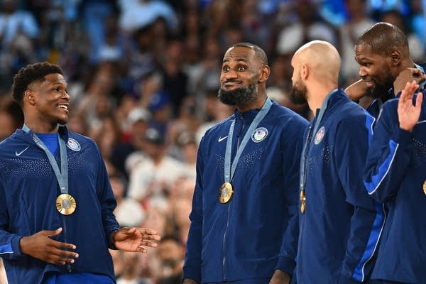 four men pose with medals