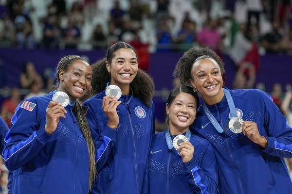 four women pose with a medals