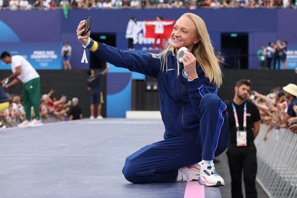 a woman takes a selfie with a medal