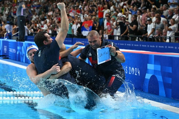 Serbia's players celebrate with their coach after winning the men's water polo gold medal match between Serbia and Croatia during the Paris 2024 Olympic Games at the Paris La Defense Arena in Paris on August 11, 2024. (Photo by Andreas SOLARO / AFP) (Photo by ANDREAS SOLARO/AFP via Getty Images)