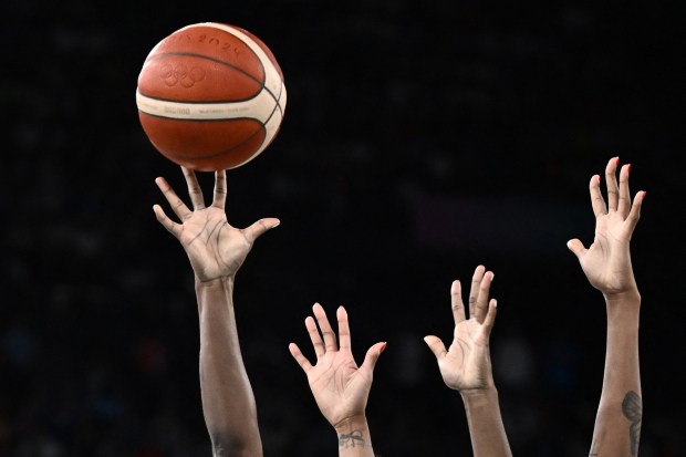 USA's #13 Jackie Young (L) and France's #11 Valeriane Ayayi go for a rebound in the women's Gold Medal basketball match between France and the USA during the Paris 2024 Olympic Games at the Bercy Arena in Paris on August 11, 2024. (Photo by Aris MESSINIS / AFP) (Photo by ARIS MESSINIS/AFP via Getty Images)