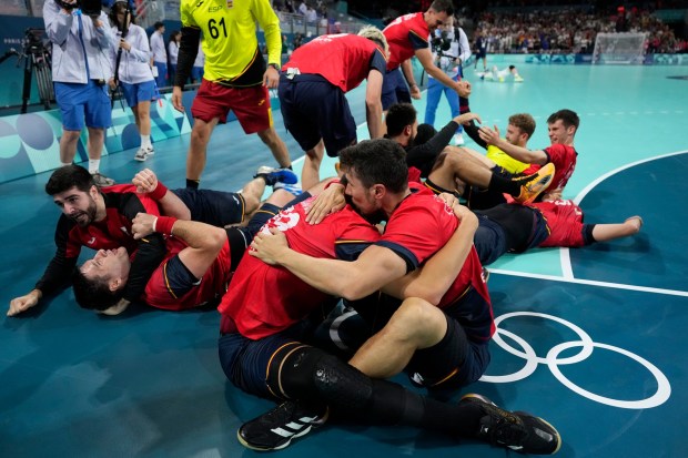 Spain players celebrate their victory after the bronze medal handball match between Spain and Slovenia at the 2024 Summer Olympics, Sunday, Aug. 11, 2024, in Villeneuve-d'Ascq, France. (AP Photo/Aaron Favila)