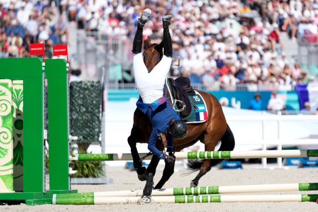 France's Marie Oteiza falls while riding Babouchka de la Bride IFCE during the final riding show of the women's individual in the modern pentathlon at the 2024 Summer Olympics, Sunday, Aug. 11, 2024, in Versailles, France. (AP Photo/Mosa'ab Elshamy)