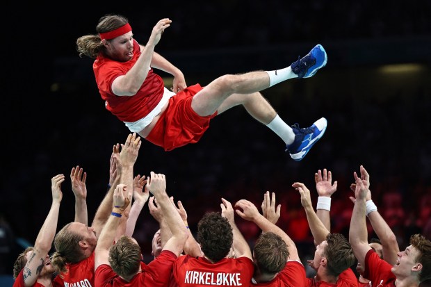 Denmark's left back #24 Mikkel Hansen is tossed at the end of the men's gold medal handball match between Germany and Denmark of the Paris 2024 Olympic Games, at the Pierre-Mauroy stadium in Villeneuve-d'Ascq, northern France, on August 11, 2024. (Photo by Sameer AL-DOUMY / AFP) (Photo by SAMEER AL-DOUMY/AFP via Getty Images)