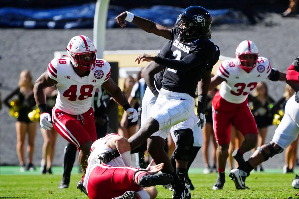 Sep 9, 2023; Boulder, Colorado, USA; Colorado Buffaloes quarterback Shedeur Sanders (2) throws the ball away while being tackled by Nebraska Cornhuskers linebacker Nick Henrich (3) in the first quarter and was penalized for intentional grounding at Folsom Field. Mandatory Credit: Ron Chenoy-USA TODAY Sports