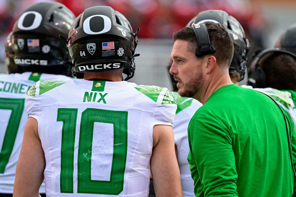 Oct 28, 2023; Salt Lake City, Utah, USA; Oregon Ducks head coach Dan Lanning talks with quarterback Bo Nix (10) during a timeout against the Utah Utes during the second half at Rice-Eccles Stadium. Mandatory Credit: Christopher Creveling-USA TODAY Sports