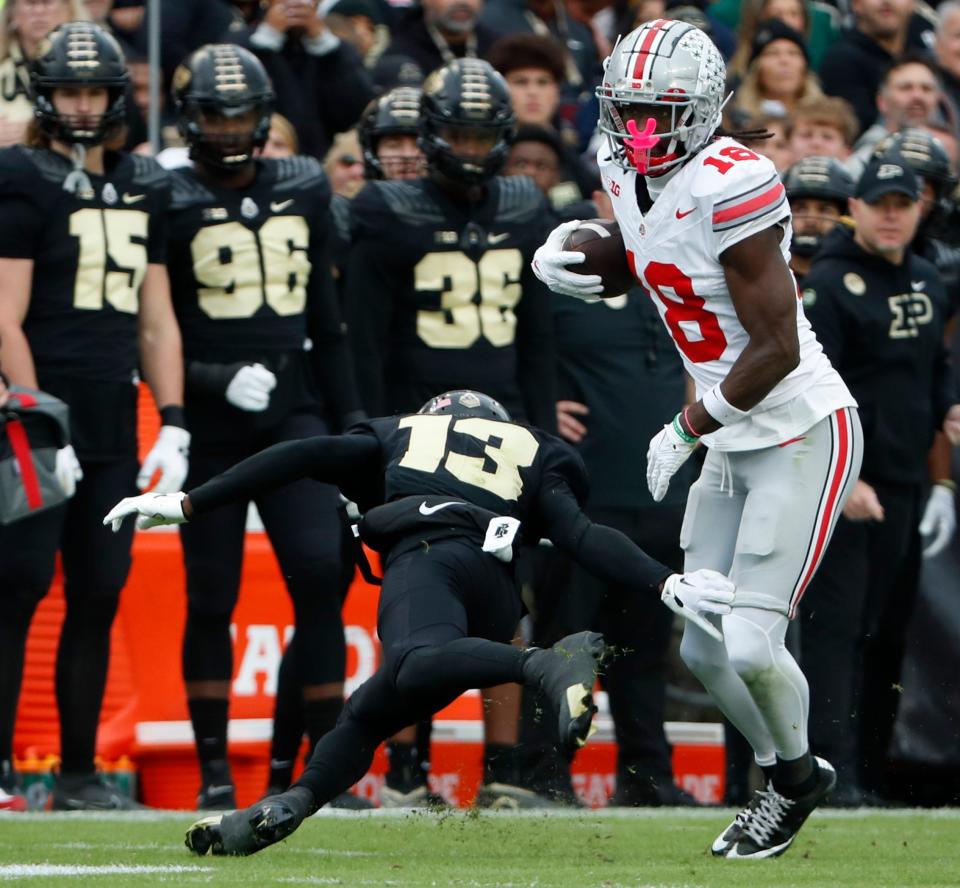 Ohio State Buckeyes wide receiver Marvin Harrison Jr. (18) breaks the tackle of Purdue Boilermakers defensive back Derrick Rogers Jr. (13) during the NCAA football game, Saturday, Oct. 14, 2023, at Ross-Ade Stadium in West Lafayette, Ind. Ohio State Buckeyes won 41-7.