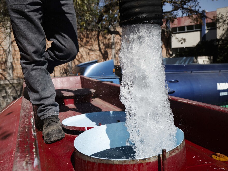 A worker with Mexico's National Water Commission fills a water truck with drinking water to be distributed in Mexico City in January 2024 after the city experienced water shortages.