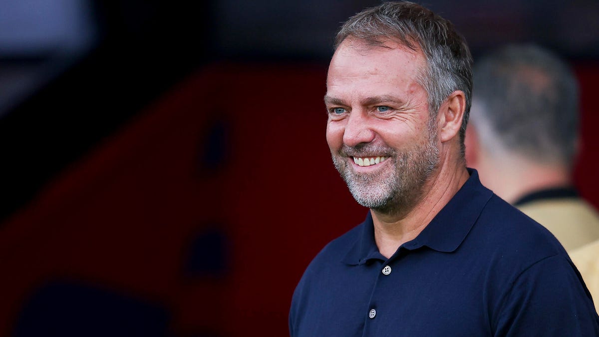 FC Barcelona head coach Hansi Flick smiling, looking to his left.