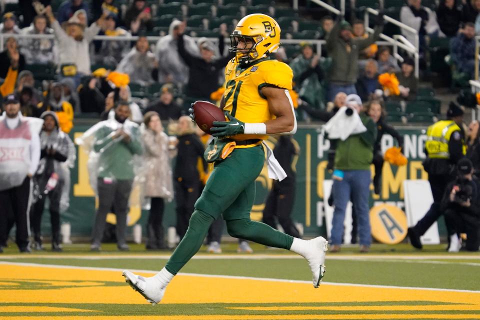 Nov 25, 2023; Waco, Texas, USA; Baylor Bears running back Dominic Richardson (21) carries the ball for a 2-yard touchdown against the West Virginia Mountaineers during the second half at McLane Stadium. Mandatory Credit: Raymond Carlin III-USA TODAY Sports