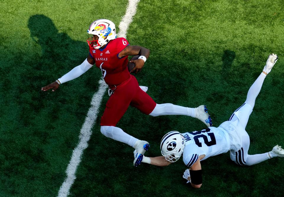 Sep 23, 2023; Lawrence, Kansas, USA; Kansas Jayhawks quarterback Jalon Daniels (6) runs the ball against Brigham Young Cougars safety Tanner Wall (28) during the second half at David Booth Kansas Memorial Stadium. Mandatory Credit: Jay Biggerstaff-USA TODAY Sports