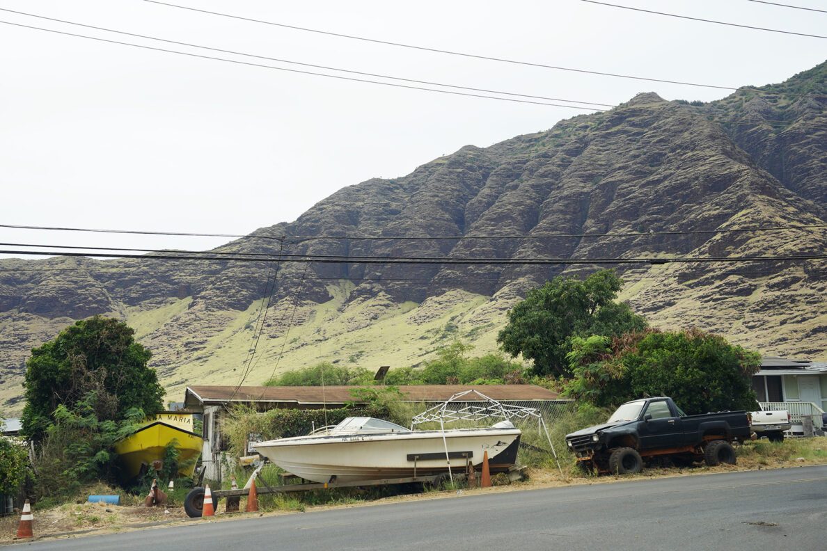 Water and land vehicles surround a home on Waianae Valley Road Tuesday, July 30, 2024, in Waianae. These locations show areas prone to wildfire, structure fires and mitigation attempts. (Kevin Fujii/Civil Beat/2024)