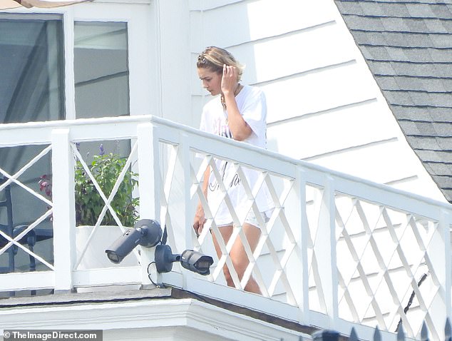 The supermodel, 29, who is best pals with the It Ends With Us star and Swift, 34, looked fresh-faced as she emerged on a balcony at the home - days after boyfriend Bradley Cooper was seen at the home