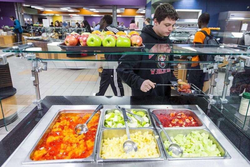 Jefferson High School freshman Austin Matheny serves himself from one of several fruit stations in 2015 in the cafeteria during lunch at Jefferson High School in Cedar Rapids. (The Gazette)