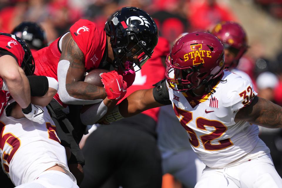 Cincinnati Bearcats running back Corey Kiner (21) carries the ball as Iowa State Cyclones linebacker Gerry Vaughn (32) defends in the first quarter during a college football game between the Iowa State Cyclones and the Cincinnati Bearcats Saturday, Oct. 14, 2023, at Nippert Stadium win Cincinnati.