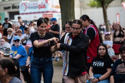 Two people dance in a crowd