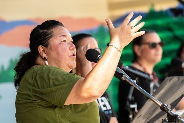 A woman talks and raises her hands