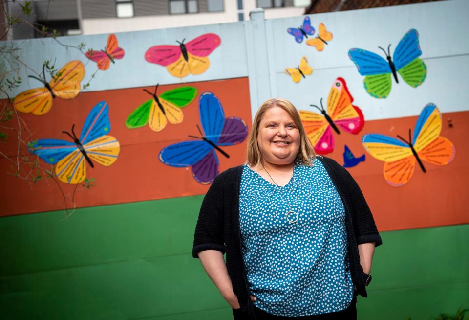 Middle Way House Executive Director Carrie Stillions poses in the courtyard of the facility on Friday, April 7, 2023.