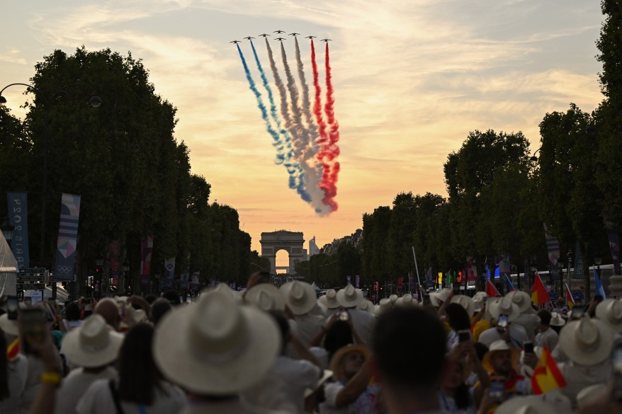 The Patrouille acrobatique de France perform a flyby whilst releasing smoke in the colours of the French flag.