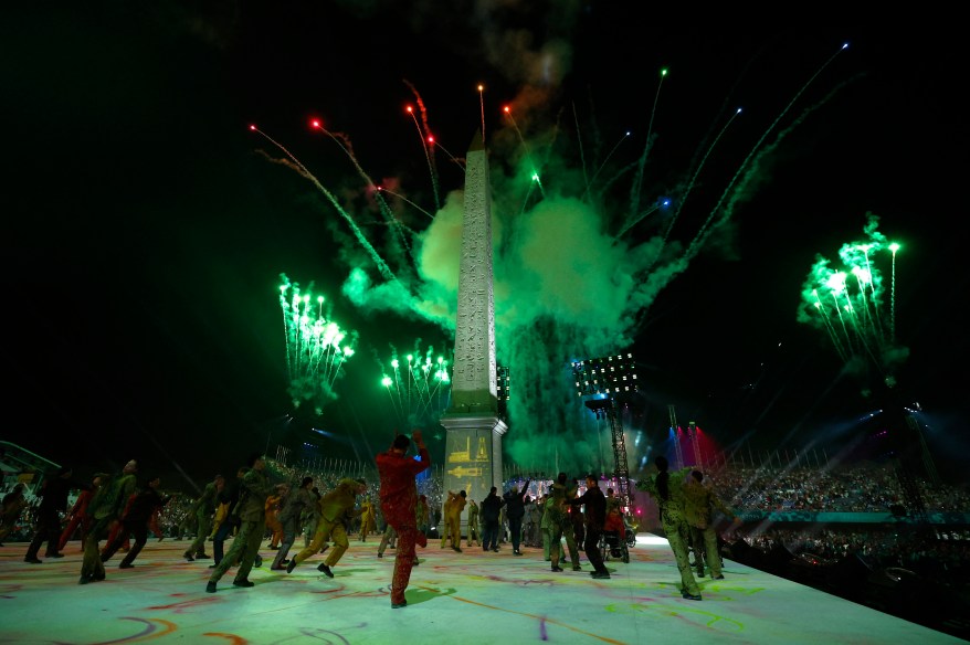 Performers during the opening ceremony as the Obelisk of Luxor on the Place de la Concorde is seen.