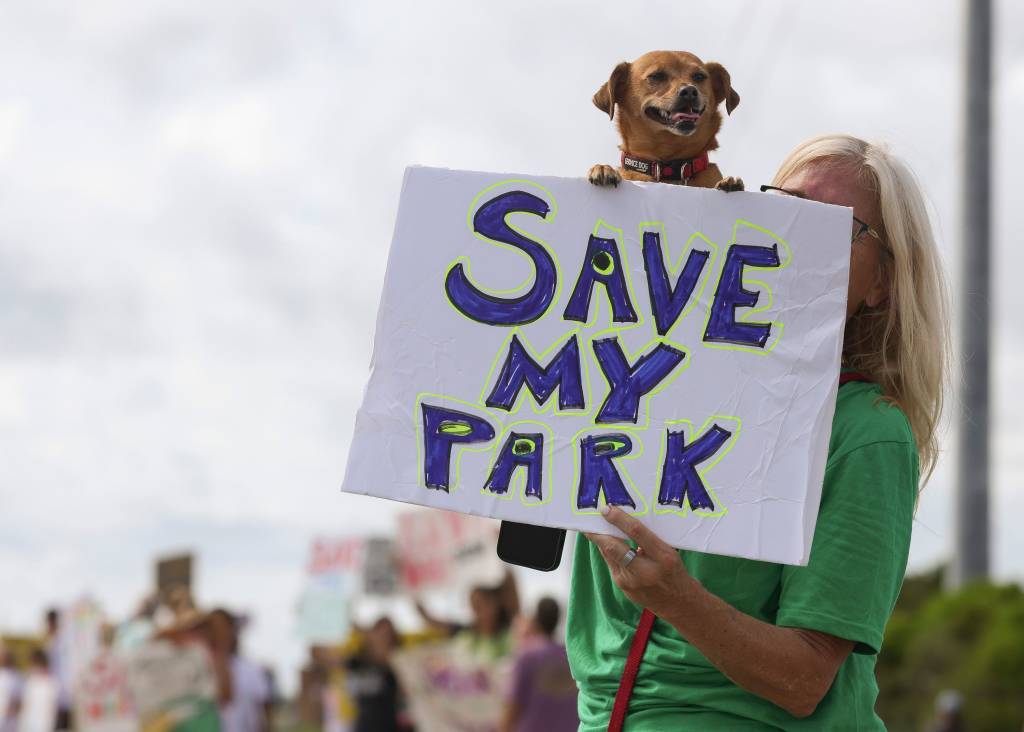 A large crowd of people gather at the front entrance of Jonathan Dickinson State Park to protest against the proposed golf courses Saturday, Aug. 24, 2024, in Martin County. Florida 