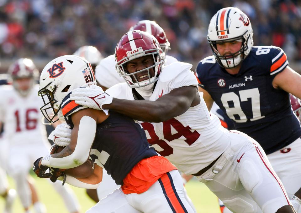 Nov 25, 2023; Auburn, Alabama, USA; Alabama Crimson Tide linebacker Quandarrius Robinson (34) tackles Auburn Tigers running back Brian Battie (21) on a kick off return at Jordan-Hare Stadium. Mandatory Credit: Gary Cosby Jr.-USA TODAY Sports