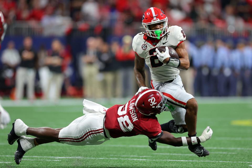 ATLANTA, GEORGIA - DECEMBER 02: Deontae Lawson #32 of the Alabama Crimson Tide tackles Kendall Milton #2 of the Georgia Bulldogs during the second quarter in the SEC Championship at Mercedes-Benz Stadium on December 02, 2023 in Atlanta, Georgia. (Photo by Kevin C. Cox/Getty Images)