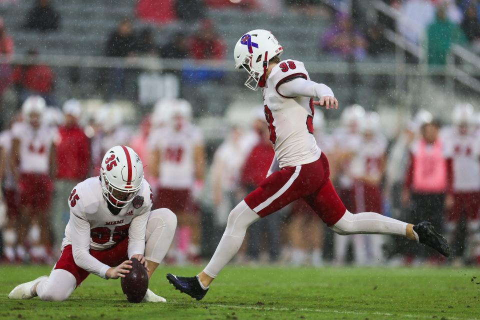 Dec 16, 2023; Orlando, FL, USA; Miami (OH) Redhawks place kicker Graham Nicholson (98) attempts a field goal held by place kicker Alec Bevelhimer (35) against the Appalachian State Mountaineers in the first quarter during the Avocados from Mexico Cure Bowl at FBC Mortgage Stadium. Mandatory Credit: Nathan Ray Seebeck-USA TODAY Sports