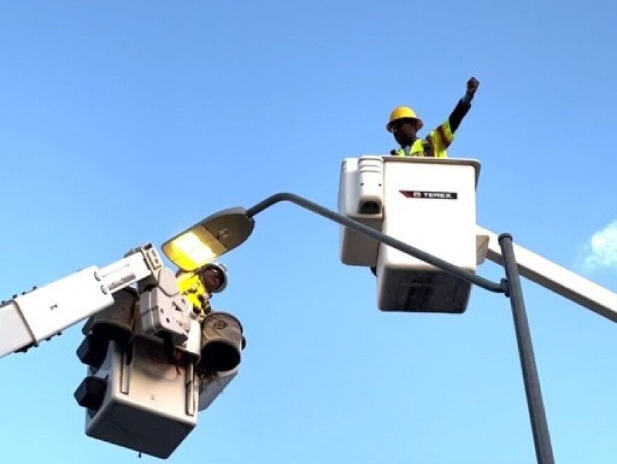 Black and McDonald electricians install LED light near 18th and Vine.