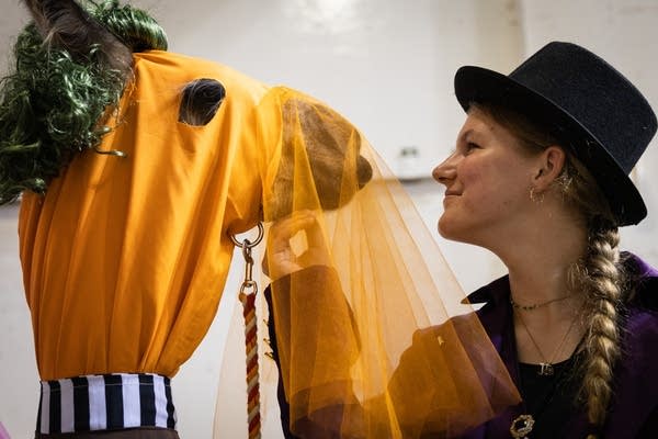 A girl scratches the chin of her llama