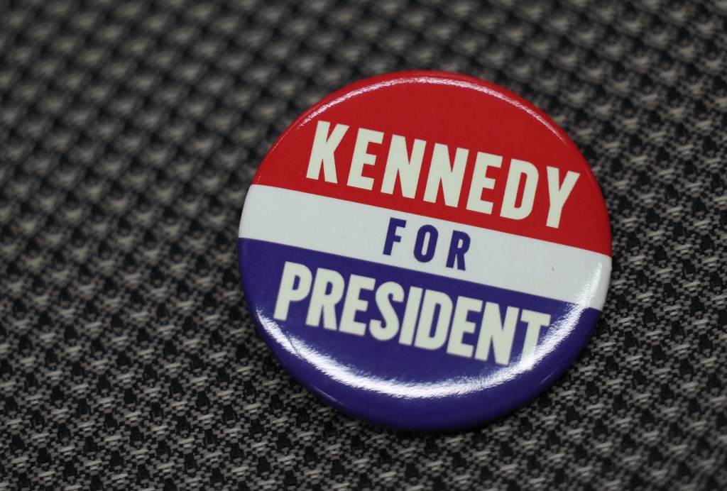 Presidential candidate Robert F. Kennedy, Jr. speaking at Libertarian National Convention with focus on his red, white, and blue campaign button