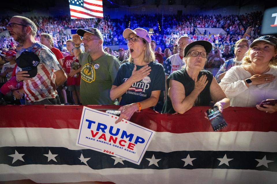 People sing the National Anthem as former President Donald Trump makes a campaign appearance Thursday, August 29, 2024 at the La Crosse Center in La Crosse, Wis. The town hall format was hosted by former Democratic congresswoman Tulsi Gabbard.