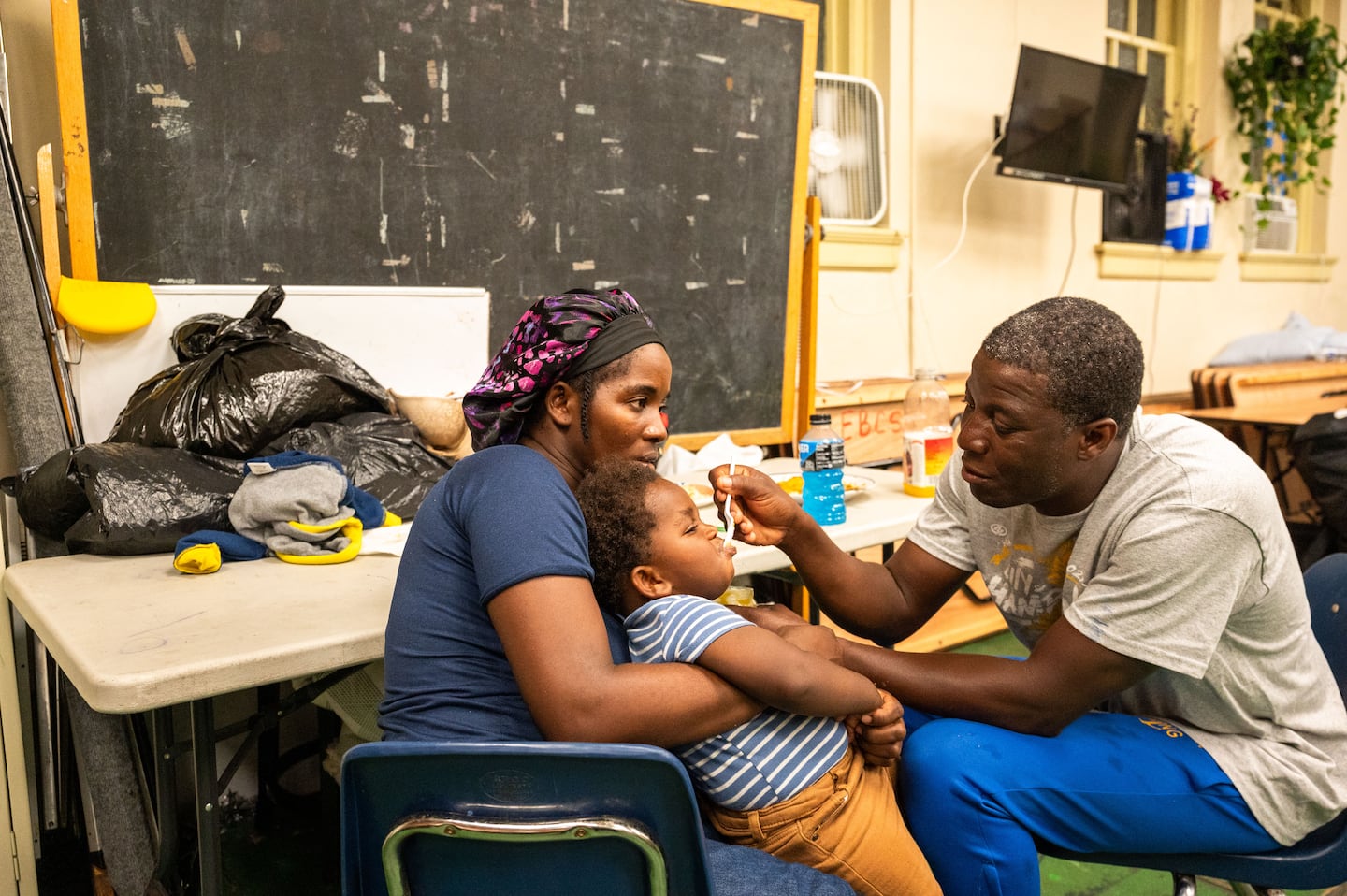  Fortunise Cene, 29, held her son Jerry Reny Cene, 1, as Jerry’s father, Jean Dadrick Reny, 42, fed him at Our Saviour's Lutheran Church in East Boston, on the evening of Aug. 26.