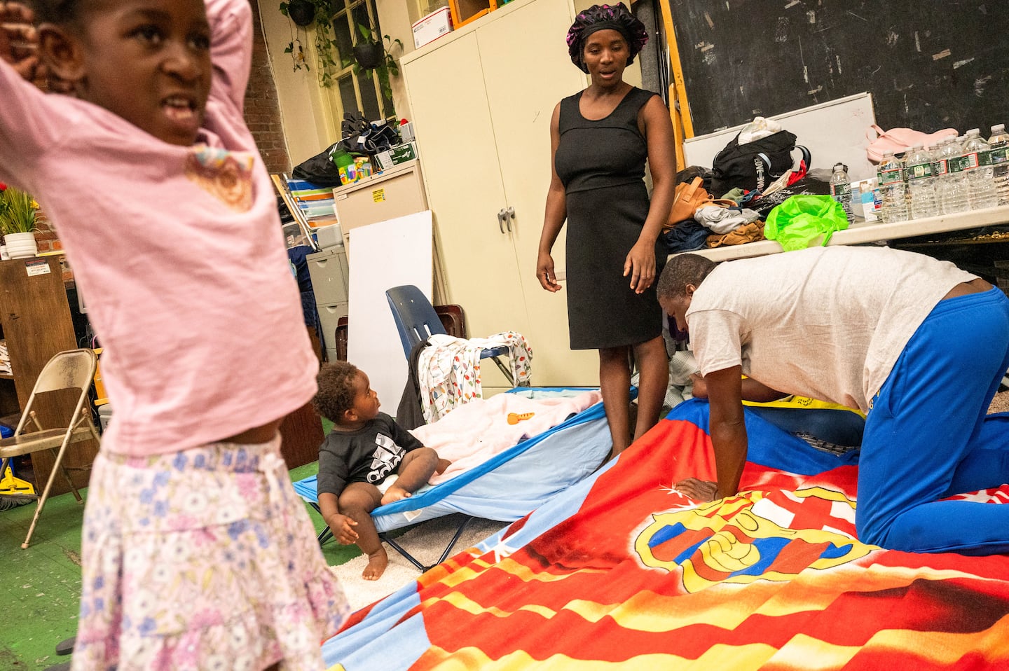 Horena Reny Cene, 5, Jerry Reny Cene, 1, Fortunise Cene, 29, and Jean Dadrick Reny, 42, set up for the night at Our Saviour's Lutheran Church in East Boston.