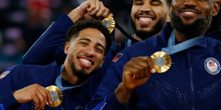 Paris 2024 Olympics - Basketball - Men's Victory Ceremony - Bercy Arena, Paris, France - August 10, 2024. Gold medallists Lebron James of United States, Tyrese Haliburton of United States, and Jayson Tatum of United States pose with their medals. REUTERS/Evelyn Hockstein