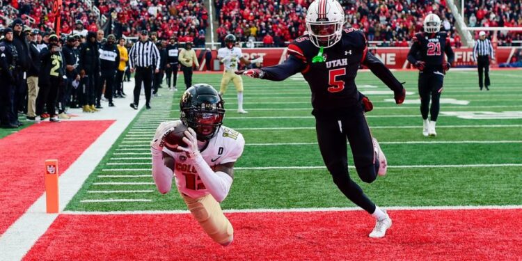 Nov 25, 2023; Salt Lake City, Utah, USA; Colorado Buffaloes athlete Travis Hunter (12) dives for a catch in the end zone in front of Utah Utes cornerback Zemaiah Vaughn (5) at Rice-Eccles Stadium. Mandatory Credit: Christopher Creveling-USA TODAY Sports