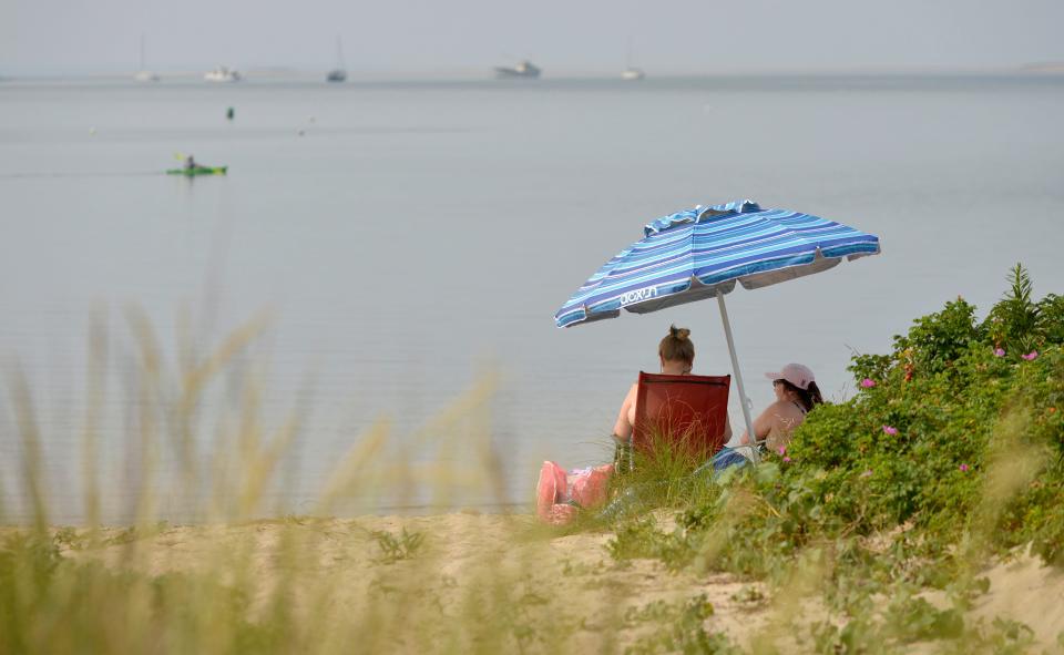 WELLFLEET -- 08/15/24 -- A blue umbrella pops up on Mayo Beach as hazy skies settle in from Canadian wildfire smoke. 
Merrily Cassidy/Cape Cod Times