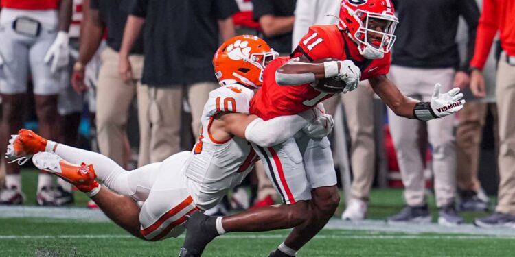 Georgia wide receiver Arian Smith (11) is tackled by Clemson cornerback Jeadyn Lukus (10) during the first quarter at Mercedes-Benz Stadium in Atlanta on Aug. 31, 2024.