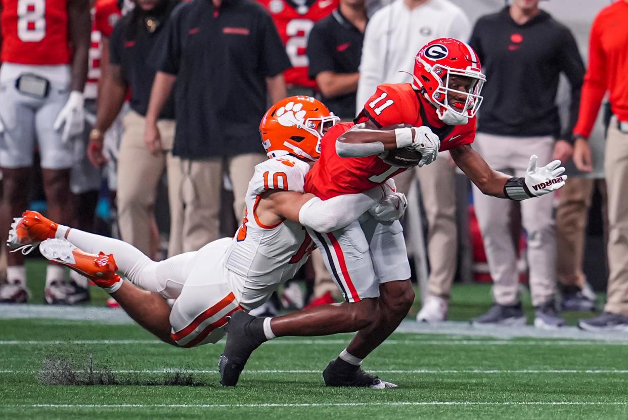 Georgia wide receiver Arian Smith (11) is tackled by Clemson cornerback Jeadyn Lukus (10) during the first quarter at Mercedes-Benz Stadium in Atlanta on Aug. 31, 2024.