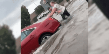 Chick-fil-A managers Sammi Young and Jarret Hartley help push stalled cars in the Chick-fil-A...