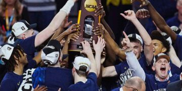 Connecticut Huskies head coach Dan Hurley and players celebrate with the trophy after defeating the Purdue Boilermakers in the national championship game of the Final Four of the 2024 NCAA Tournament at State Farm Stadium in Glendale on April 8, 2024.