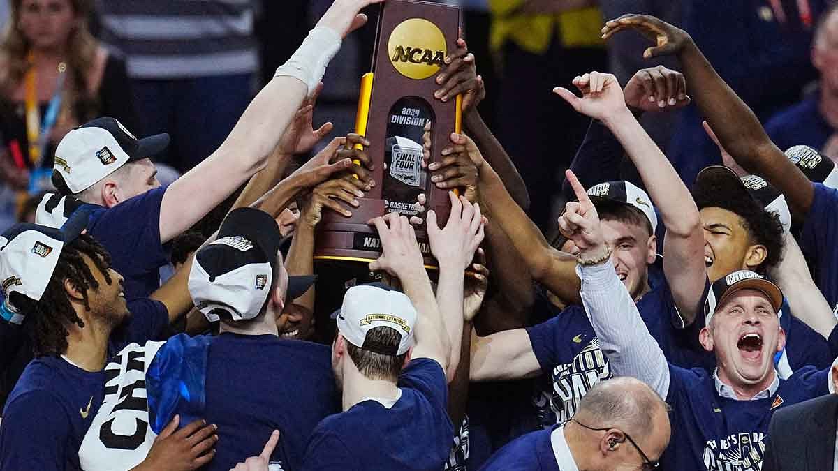 Connecticut Huskies head coach Dan Hurley and players celebrate with the trophy after defeating the Purdue Boilermakers in the national championship game of the Final Four of the 2024 NCAA Tournament at State Farm Stadium in Glendale on April 8, 2024.