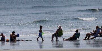 A family enjoys the sun, the sand and the sounds of the surf at Nantasket Beach.