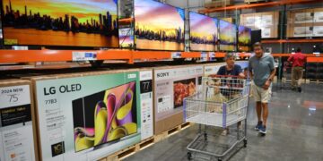 Shoppers make their way past a display of large screen TVs in the electronics department of Costco Wholesale a Costco in North Port, Florida, on June 5, 2024.