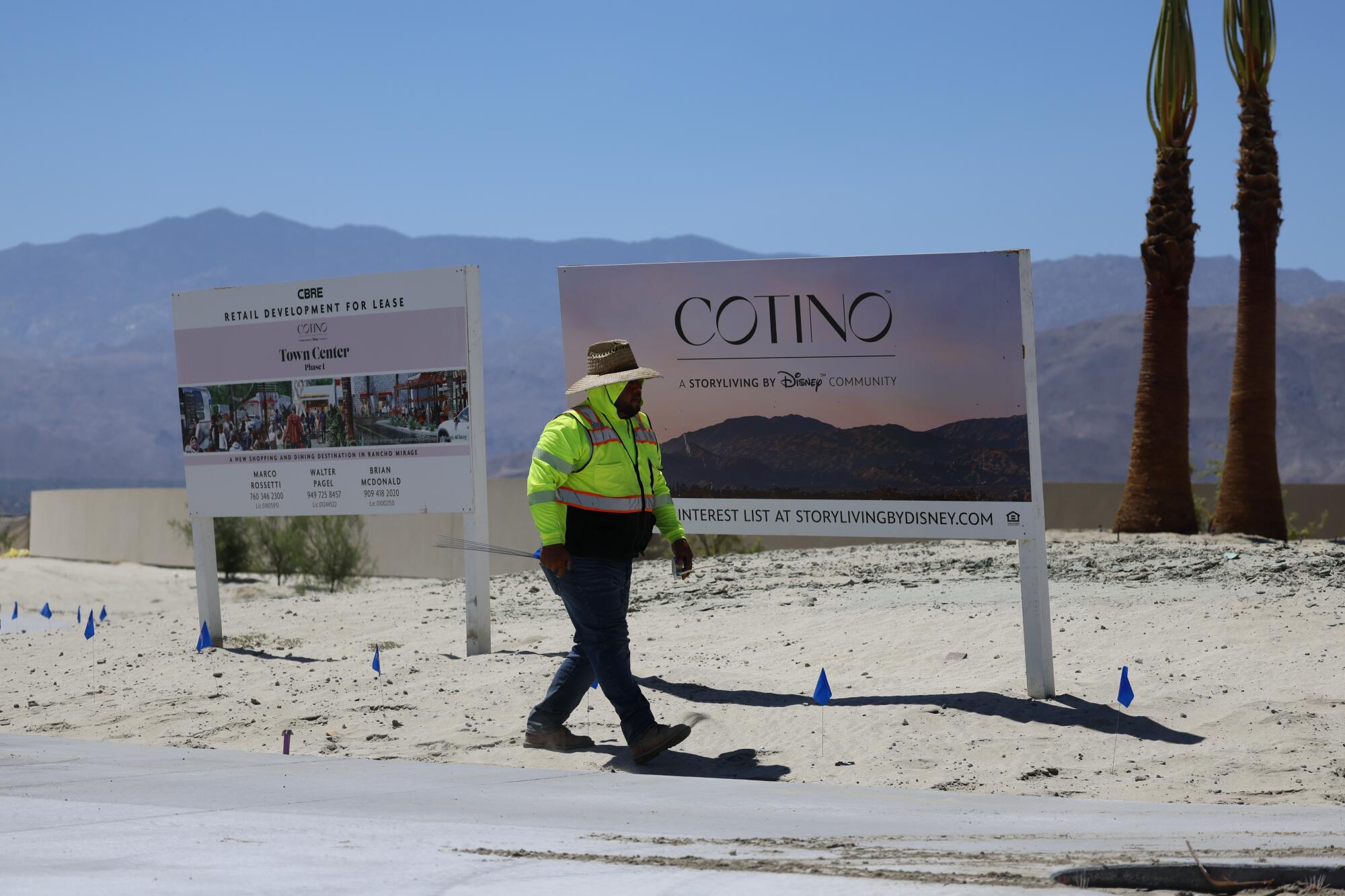 A worker walks by a sign that says Cotino. Disney is building the master-planned community in Rancho Mirage, Calif.