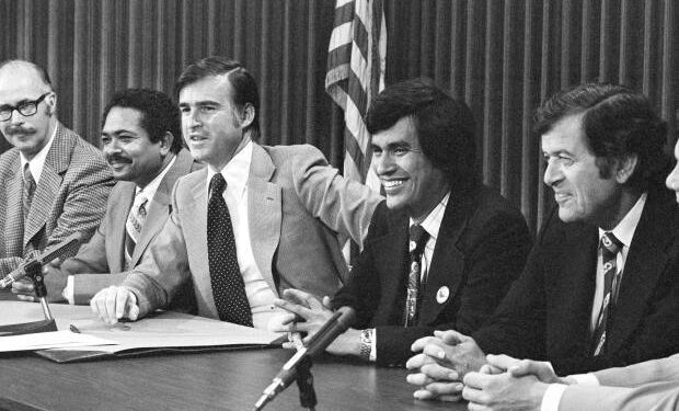 A happy California Gov. Edmund G. Brown Jr. with Lt. Gov. Mervyn Dymally, left, gave Assemblyman Richard Alatorre, a pat on the back as he talked to reporters following his signing of a landmark farm labor bill at the Capitol in Sacramento on Thursday, June 6, 1975. The bill takes effect Aug. 28 and will allow state-supervised secret ballot farm labor elections during two key fall agriculture harvests. Alatorre was one of the chief authors of farm labor legislation. (AP Photo)